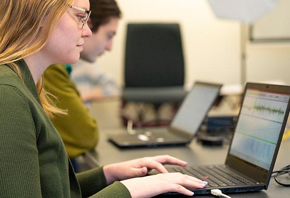 Image of a students on computers monitoring brain activity