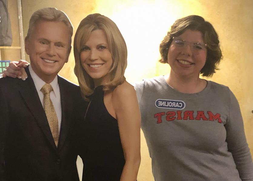 Photo of Caroline Fiske with cardboard cutouts of Pat Sajak and Vanna White