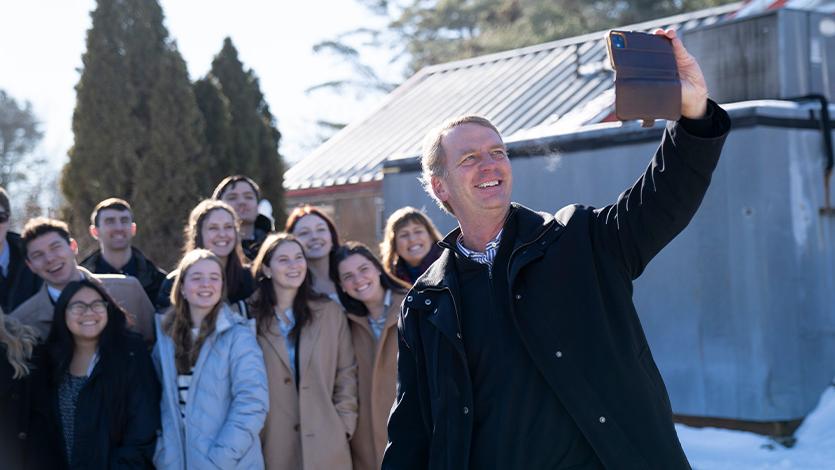 Image of President Weinman taking selfie with students.