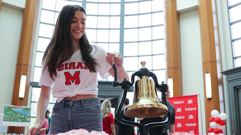 Image of student ringing deposit bell. 